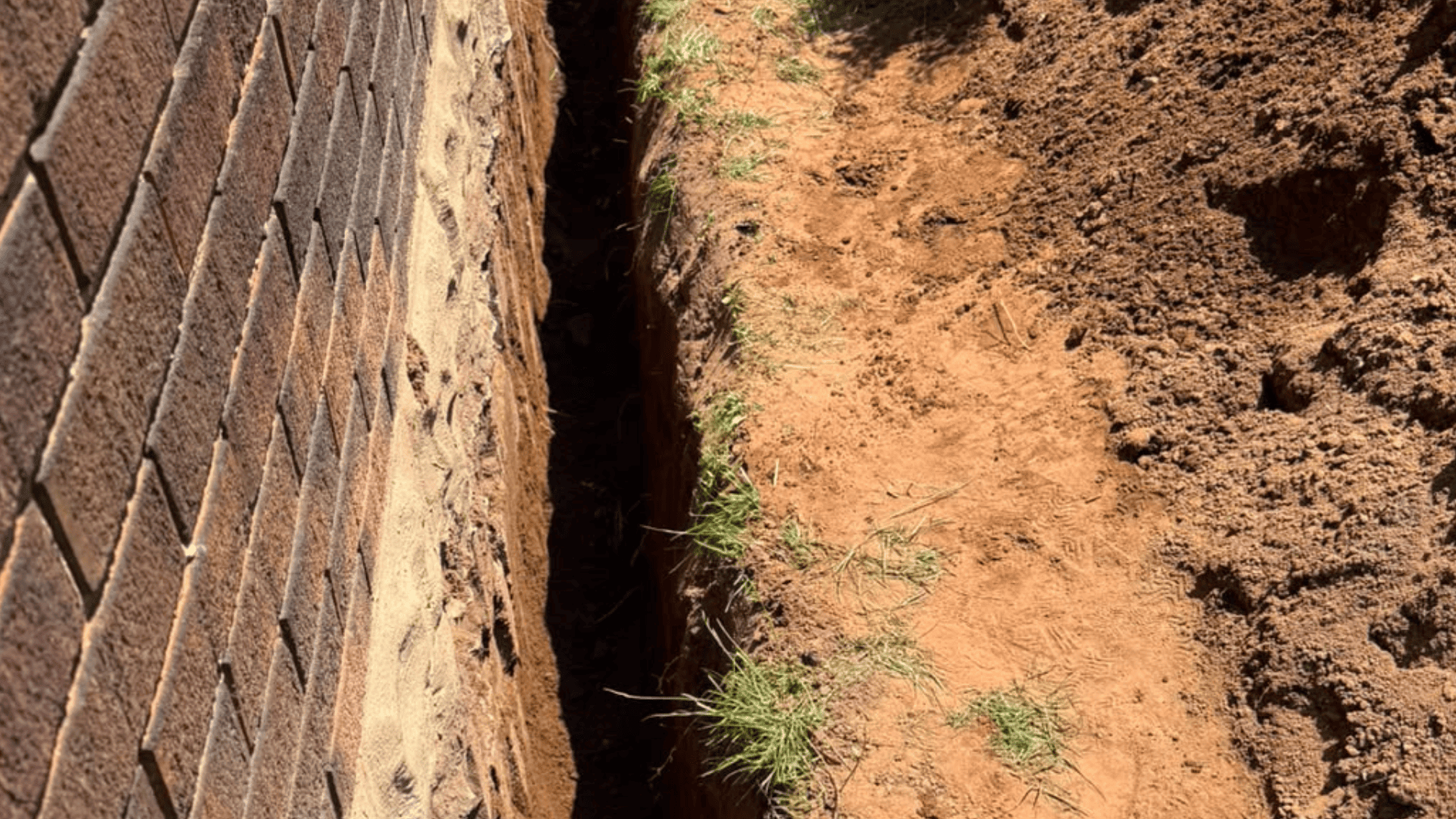 House foundation waterproofing, trench dug along the base of the house